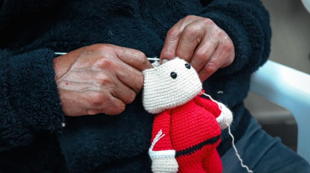 Participante elaborando amigurumis navideños mediante técnicas de tejido artesanal
